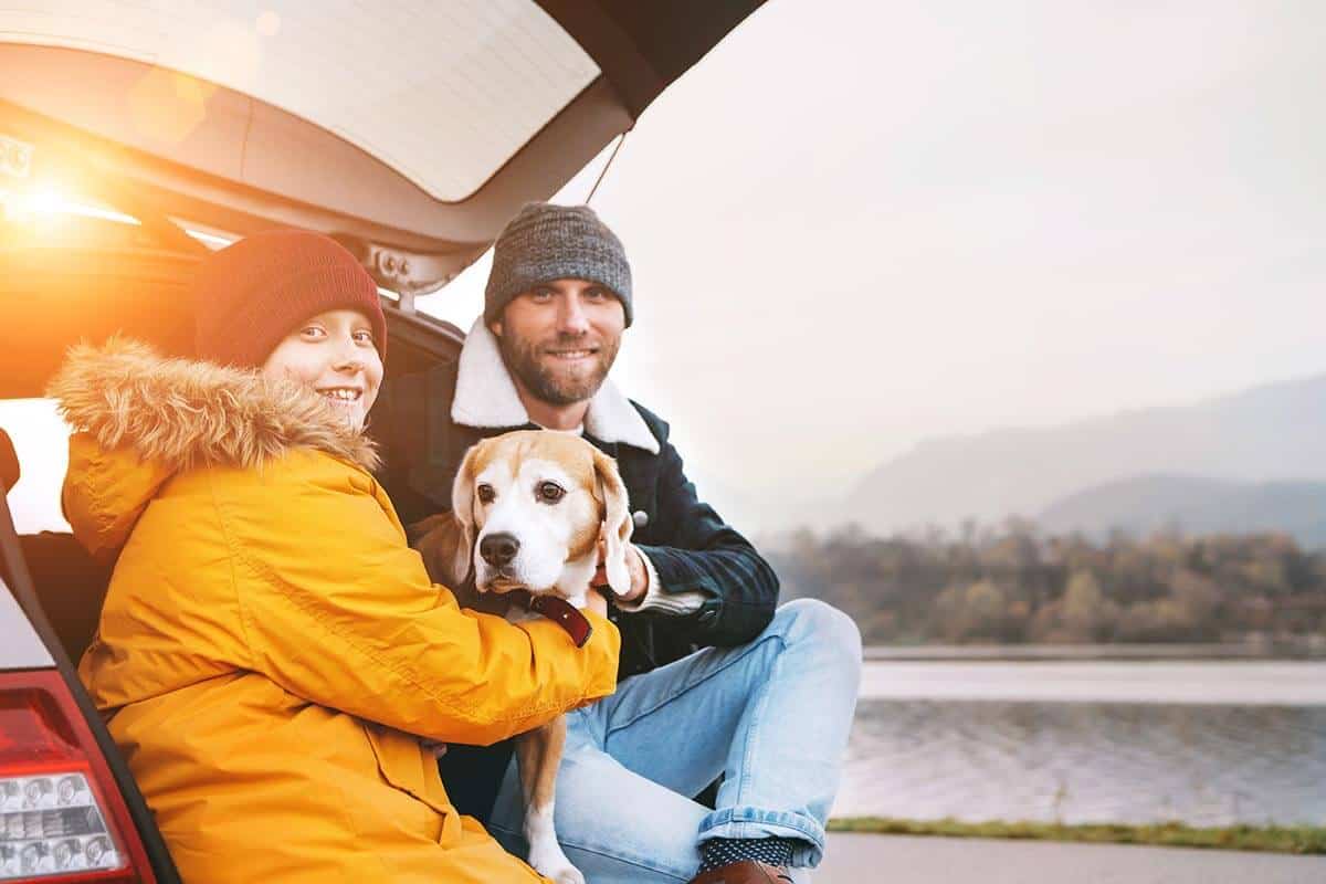 Family with their dog near mountain lake